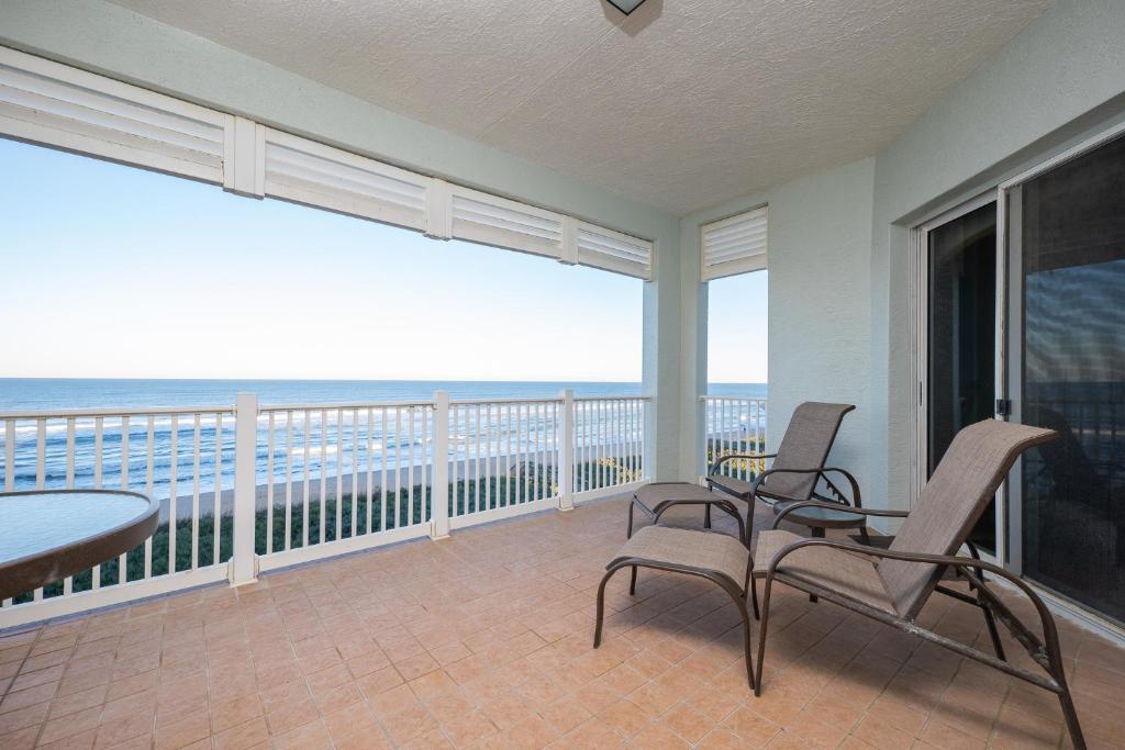 a balcony with chairs and a table and a view of the ocean at 852 Cinnamon Beach in Palm Coast