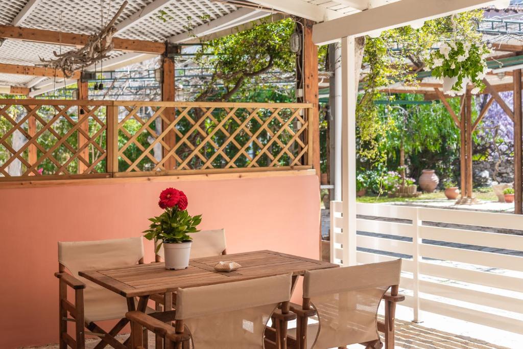a wooden table and chairs on a porch with a window at Τrilogy Studios in Syvota