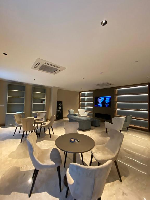 a living room with tables and chairs and a tv at EUROPA Hotel in Vasto