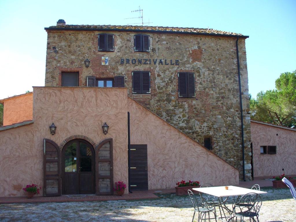 ein Gebäude mit einem Tisch davor in der Unterkunft Agriturismo Bronzivalle in Riotorto