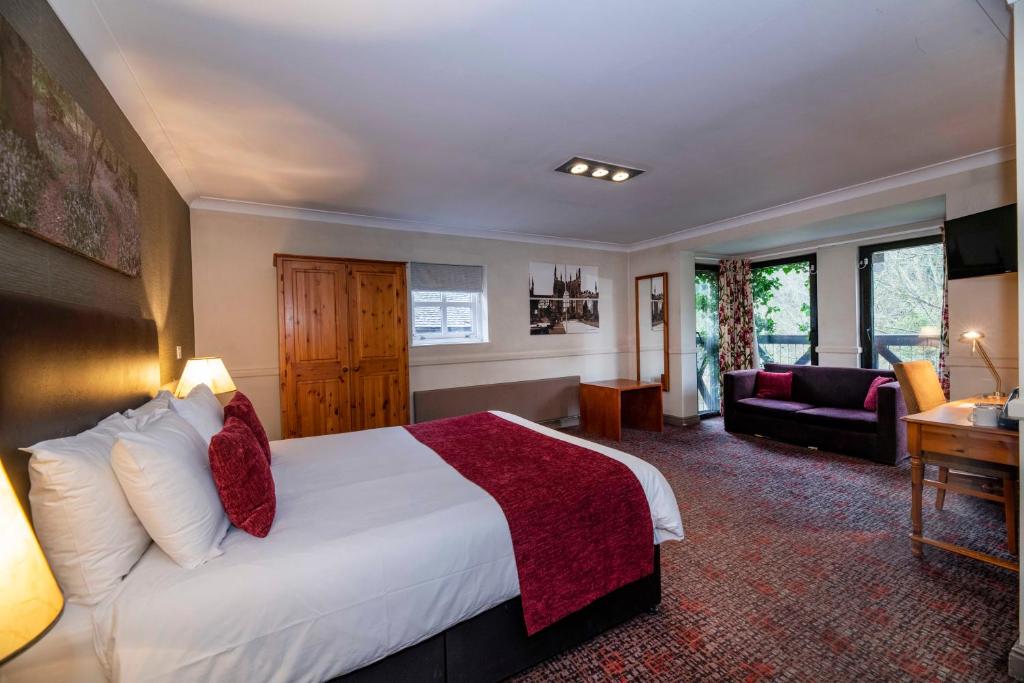 
a bedroom with a large bed and a large window at Old Mill Hotel by Greene King Inns in Coventry
