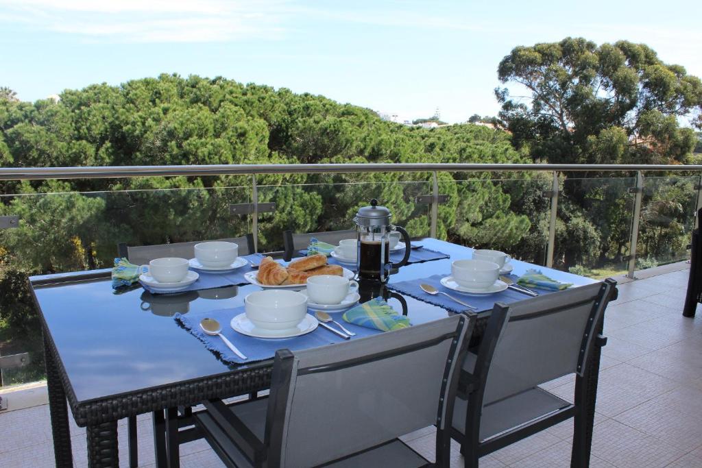 a table with a tea set on top of a balcony at Casa Jacqueline in Albufeira