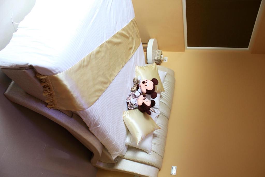 a doll sitting on the bottom of a bed at Xinyue B&amp;B in Fenglin