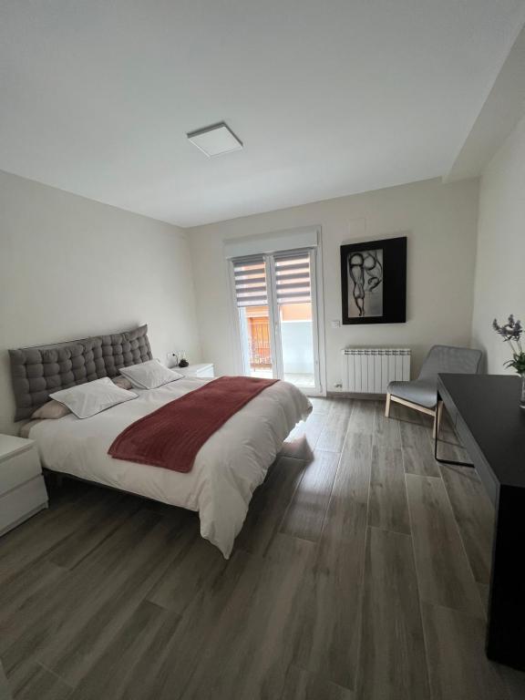 una camera bianca con un grande letto e una scrivania di Casa Leo a Teruel