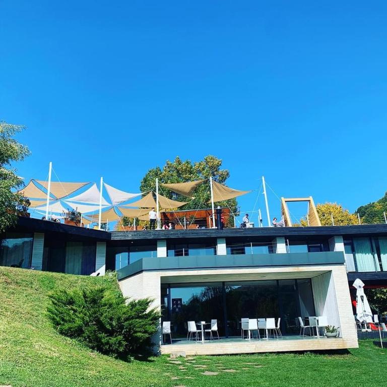 a building with chairs and tables on the balcony at Pensiunea Atra Doftana in Teşila