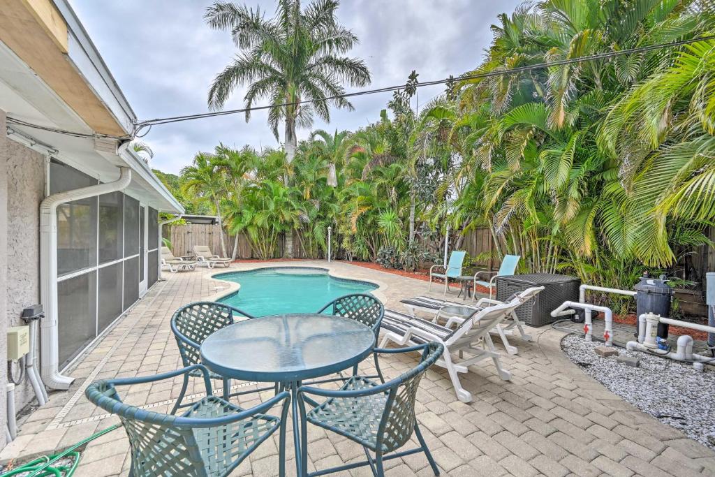 une terrasse avec une table, des chaises et une piscine dans l'établissement Pelican Nest, Tropical Naples Villa with Pool, à Naples