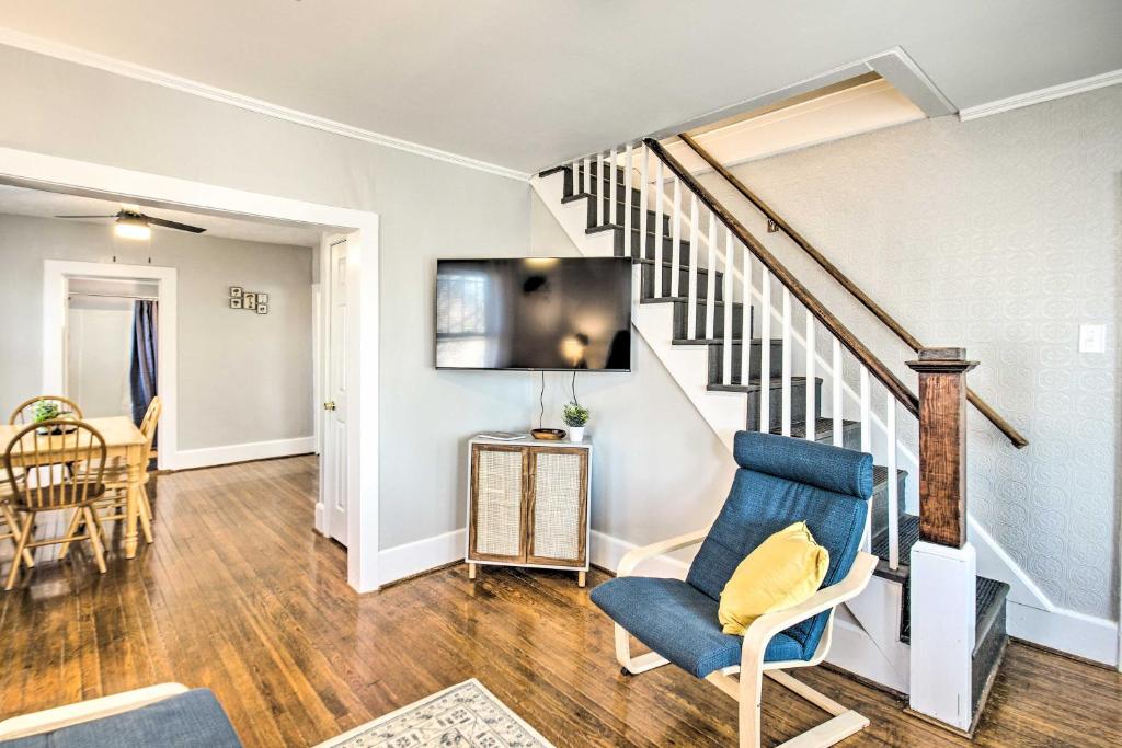 a living room with a blue chair and stairs at Historic Staunton Home about 1 Mi to Downtown! in Staunton