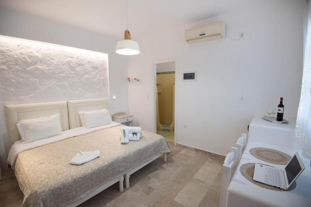 a bedroom with two beds and a table with a laptop at Eleana Studios in Ambelas