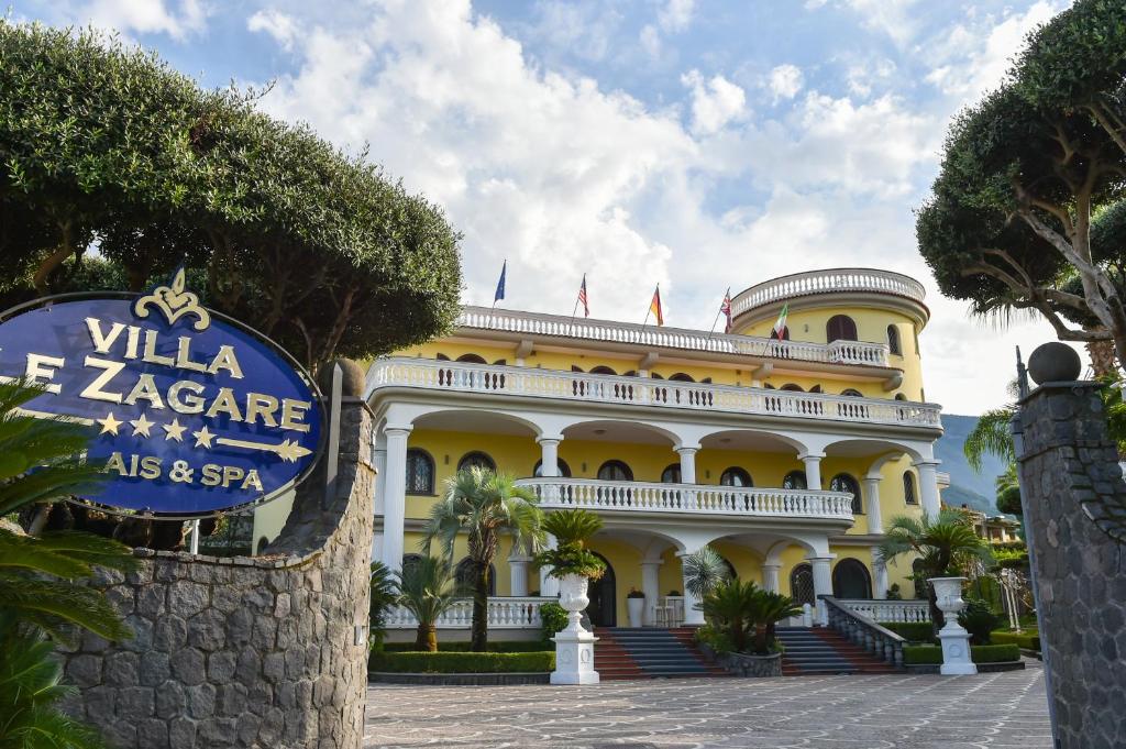 un gran edificio amarillo con un cartel delante en Villa Le Zagare Relais & SPA en Gragnano