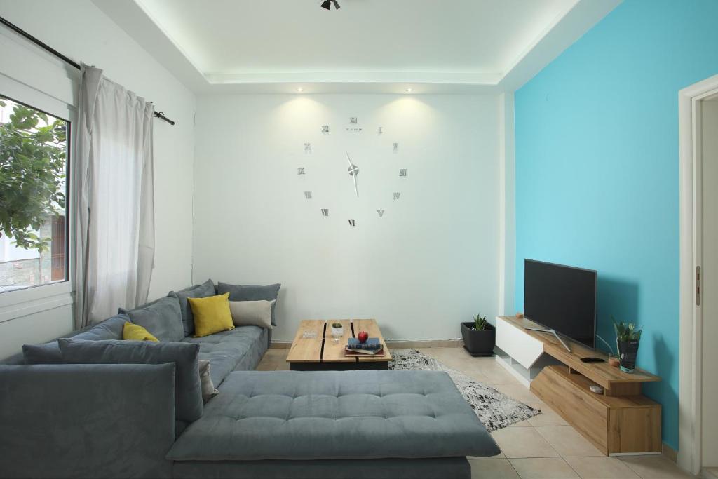 a living room with a couch and a clock on the wall at Nikea apartment near Piraeus port and metro st I in Piraeus