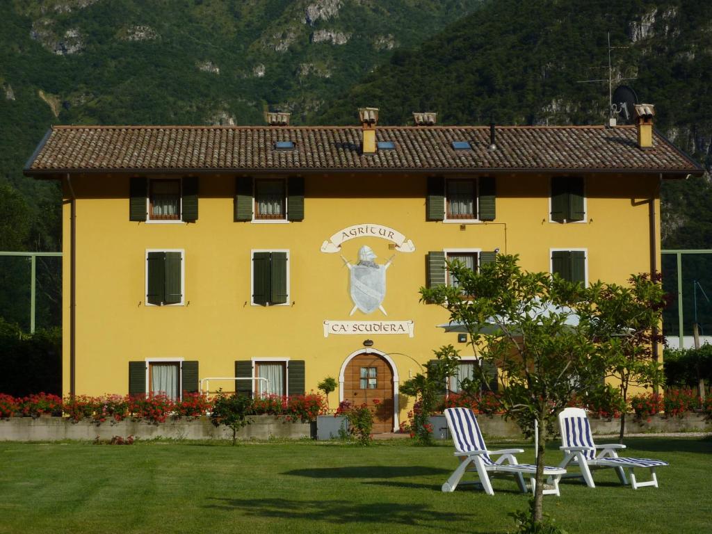 a yellow building with two chairs in front of it at Agritur Ca' Scudiera in Belluno Veronese