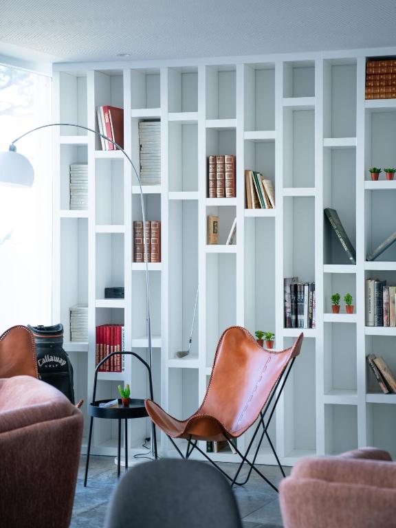 a living room with chairs and bookshelves at A House in Estoril - Adults Only in Estoril
