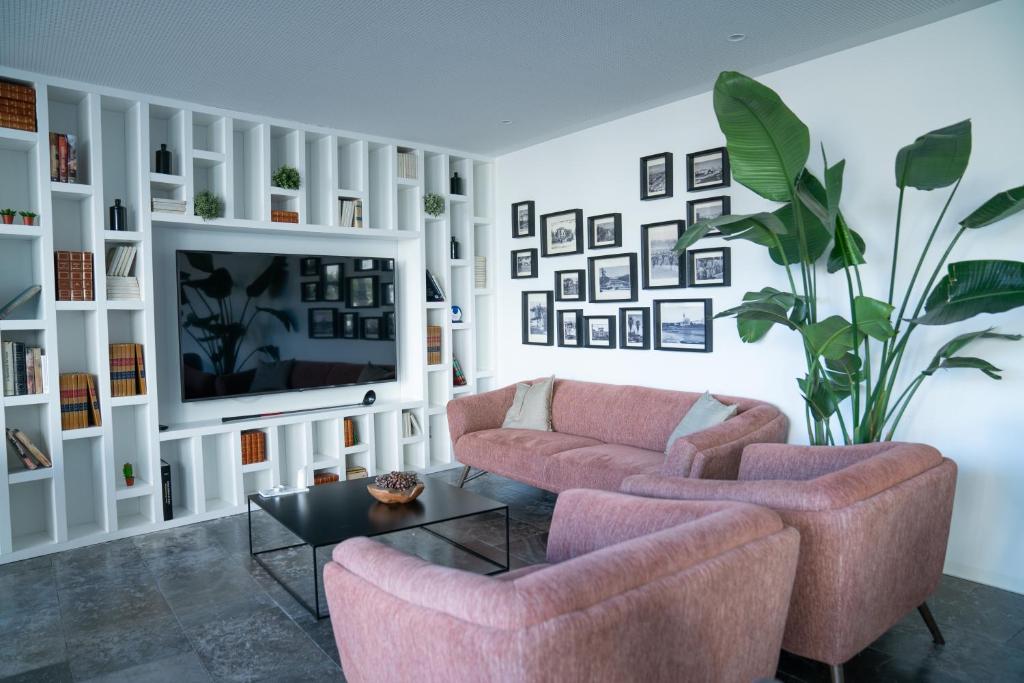 a living room with two chairs and a tv at A House in Estoril - Adults Only in Estoril