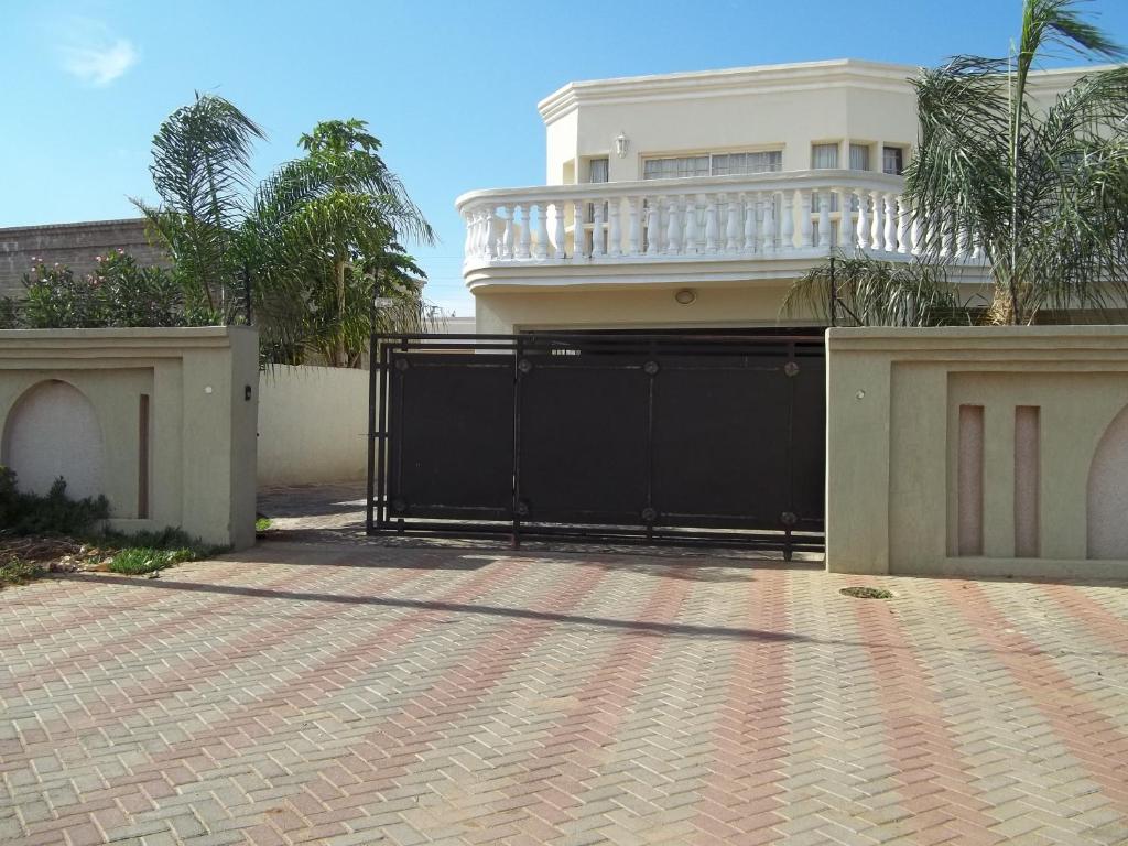 um portão preto em frente a uma casa em Carlcyn Homestay em Gaborone