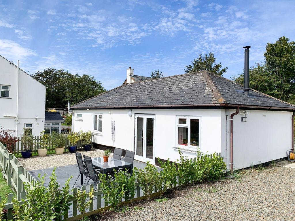 a white cottage with a table in front of it at Lowenek in Bodmin