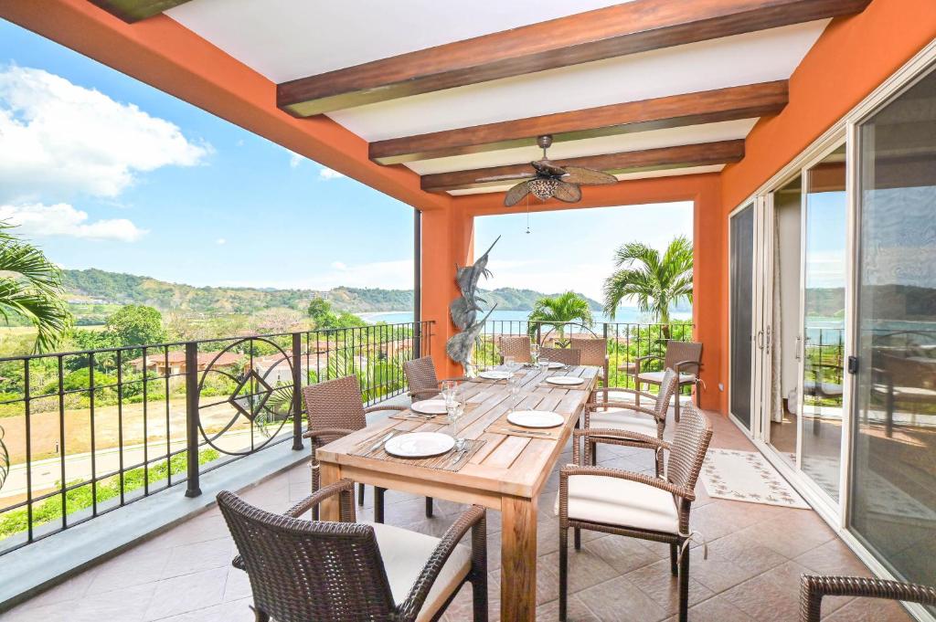a dining room with a table and chairs on a balcony at Los Suenos Resort Montebello 2C by Stay in CR in Herradura
