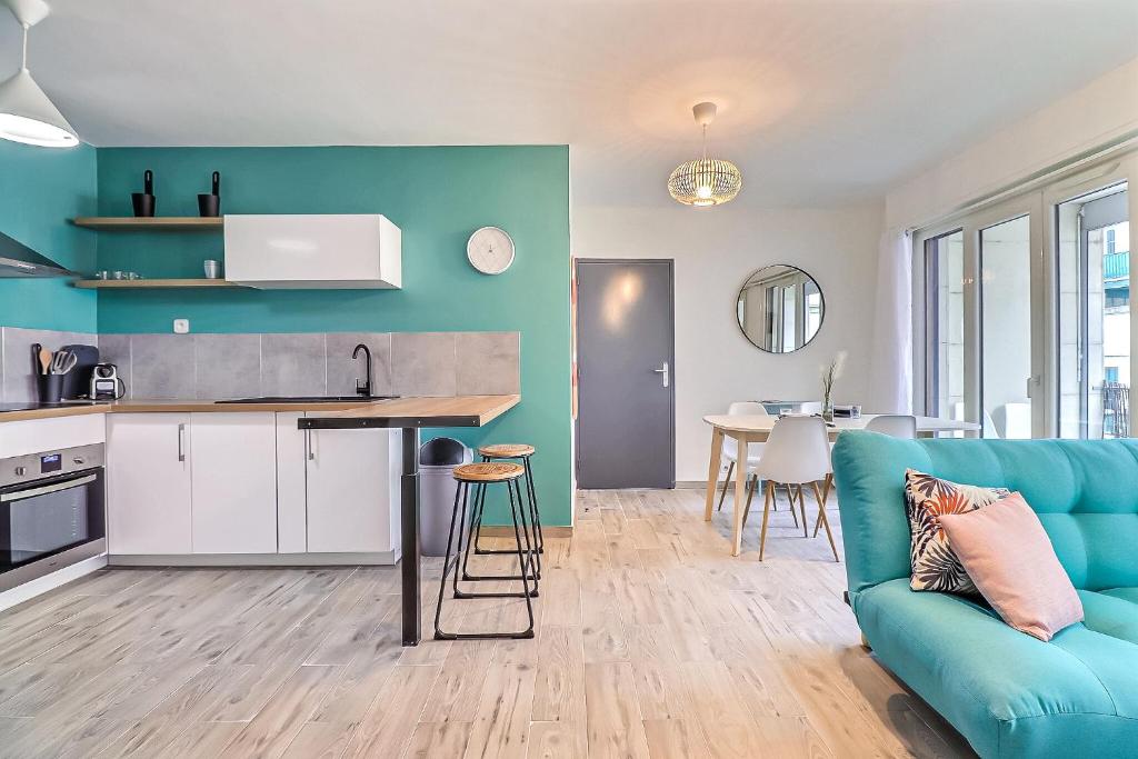 Il comprend un salon avec un canapé bleu et une cuisine. dans l'établissement Atlas - Superbe logement plein centre - Terrasse, à Nîmes