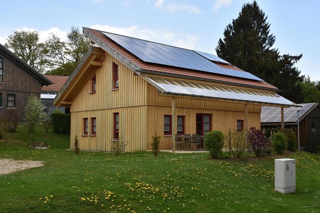 瓦爾德明興的住宿－Ferienhaus Nr 2C plus, Feriendorf Hagbügerl, Bayr Wald，屋顶上设有太阳能电池板的房子
