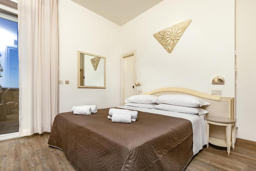 Postel nebo postele na pokoji v ubytování Ariminum Hotel