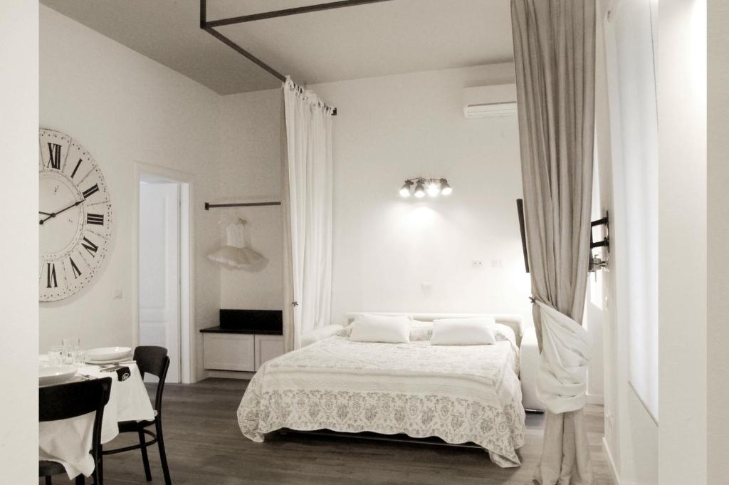 ローマにあるTrastevere Residenceの白いベッドルーム(ベッド1台、大きな時計付)