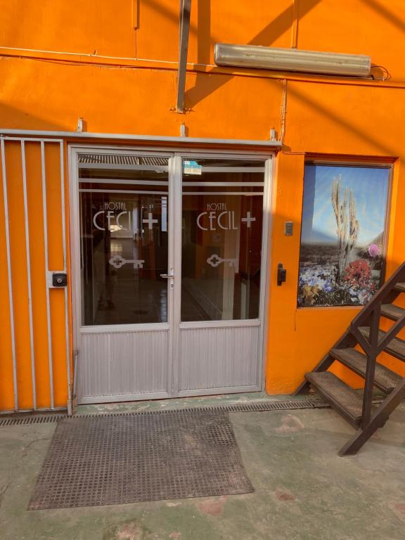 ein orangefarbenes Gebäude mit einer Tür und einem Fenster in der Unterkunft Hostal CECIL + in Vallenar