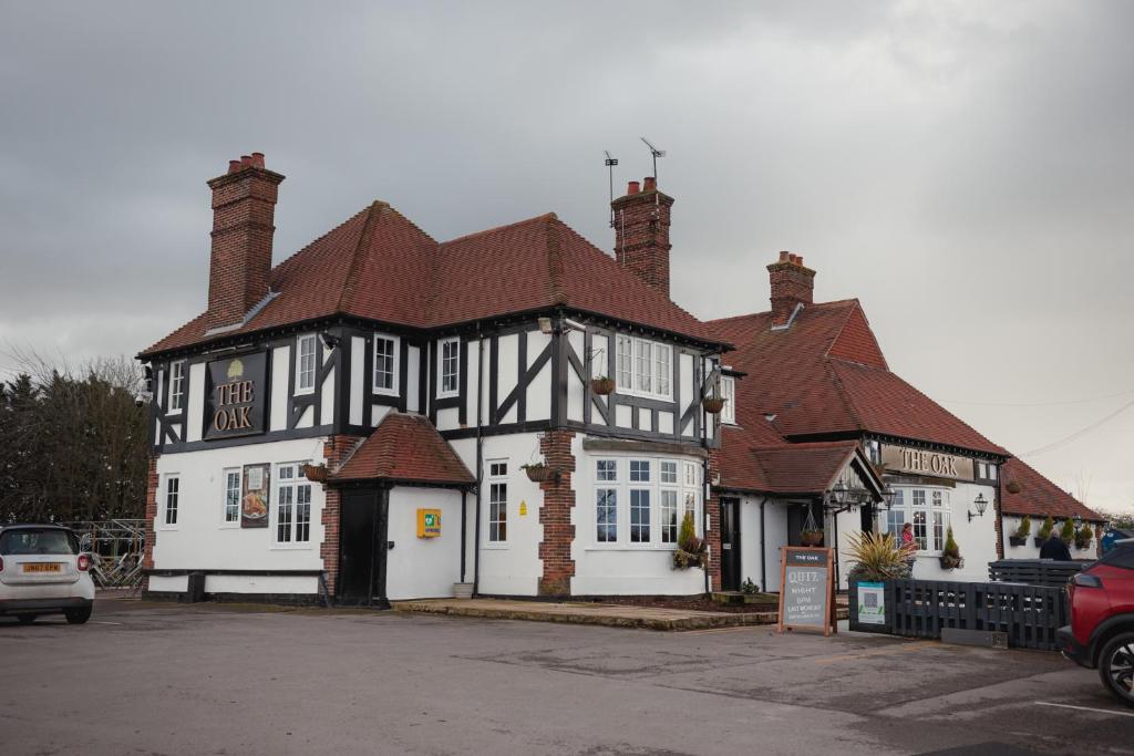 a large white and black building with a roof at The Oak Baginton in Coventry