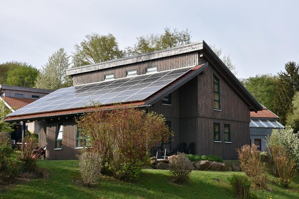 um celeiro com painéis solares no telhado em Ferienhaus Nr 16A3, Feriendorf Hagbügerl, Bayr Wald em Waldmünchen