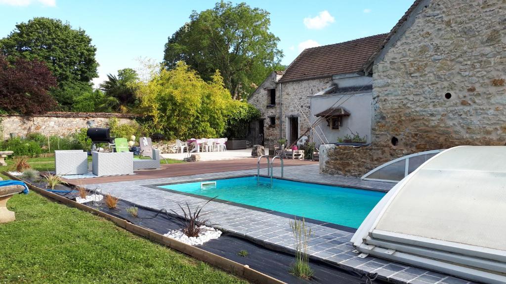 - une piscine dans l'arrière-cour d'une maison dans l'établissement GITE HARY, à Villeblevin