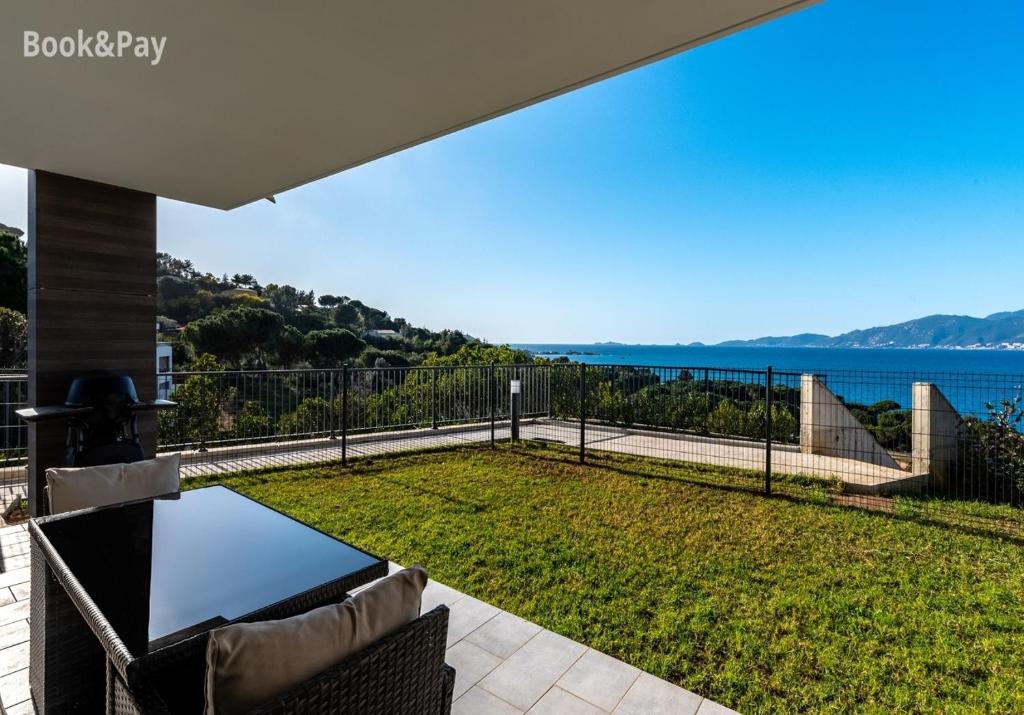 d'une terrasse avec une table et une vue sur l'eau. dans l'établissement L'escapade Stagnola, à Pietrosella