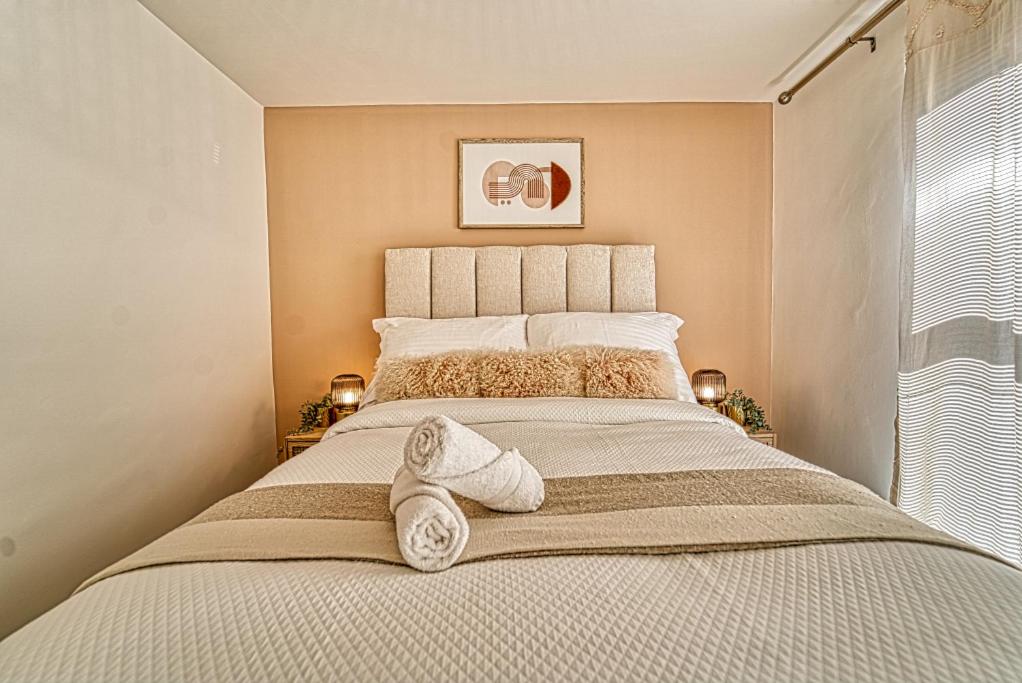 een slaapkamer met een groot bed en handdoeken bij Guest Homes - Watledge House Apartment in Tewkesbury