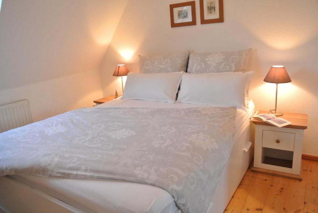 a bedroom with a large bed with white sheets and pillows at FischLANDinSicht in Ribnitz-Damgarten