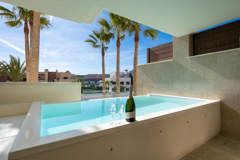 a swimming pool with a bottle of wine in a house at Holiday Apartment Azalea La Cala in La Cala de Mijas