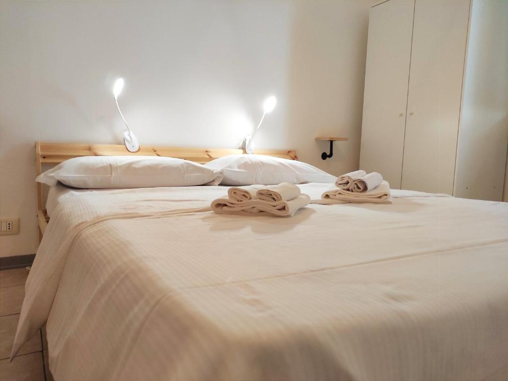 a large white bed with two towels on it at Airport Inn Preturo Affittacamere in San Vittorino