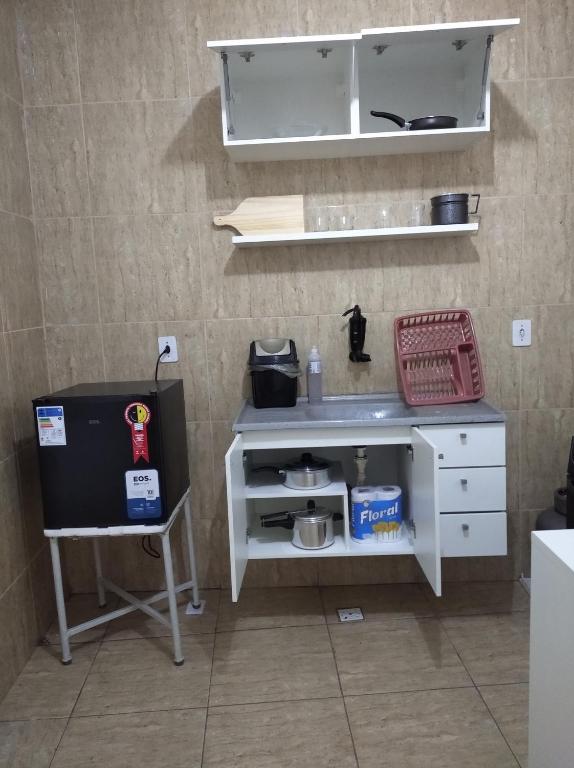 uma cozinha com um armário branco e um lavatório em Flat estação em Juazeiro do Norte