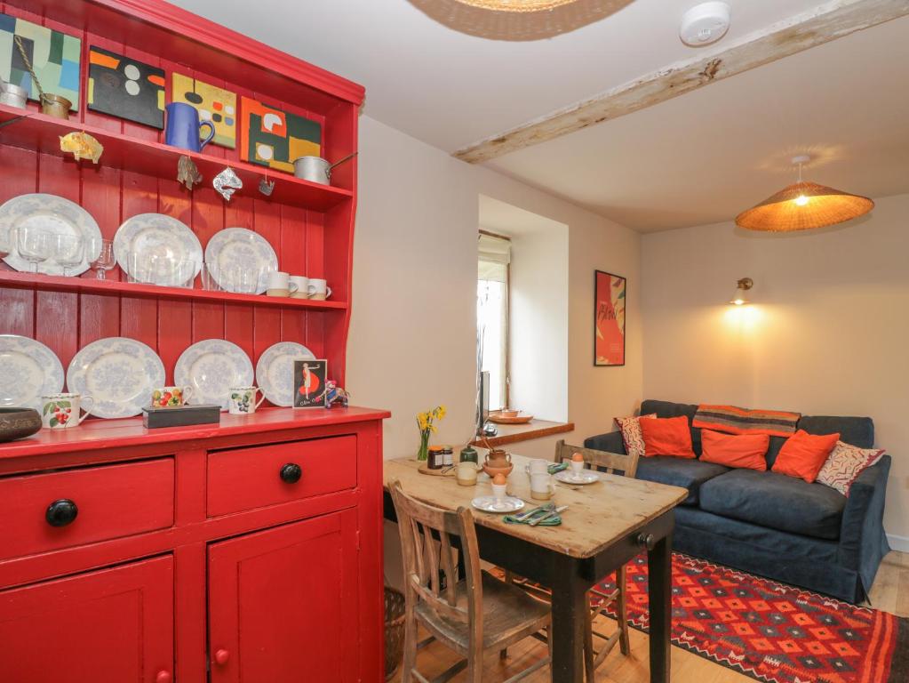 a living room with a red cabinet and a table at The Old Stables in Usk