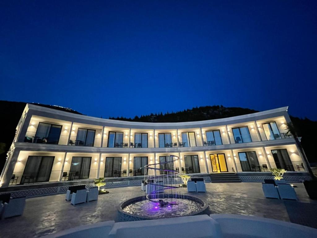 a large building with a courtyard at night at EBBI HOTEL in Dhërmi