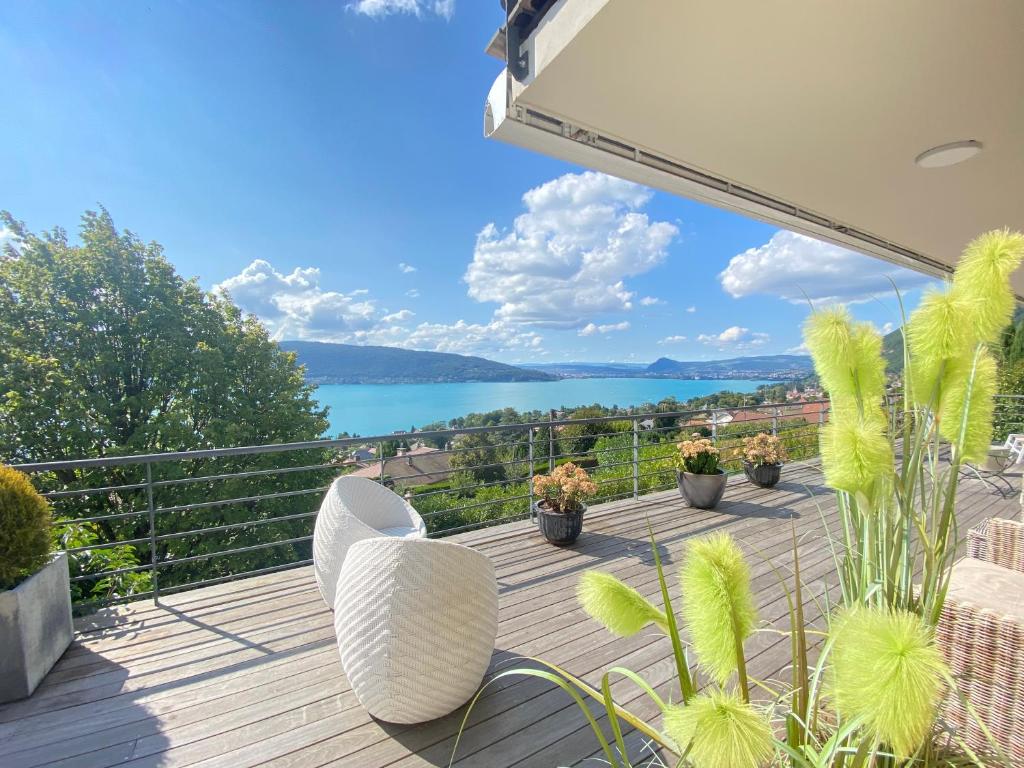 einen Balkon mit Stühlen und Blick auf das Wasser in der Unterkunft Villa Zenitude in Veyrier-du-Lac