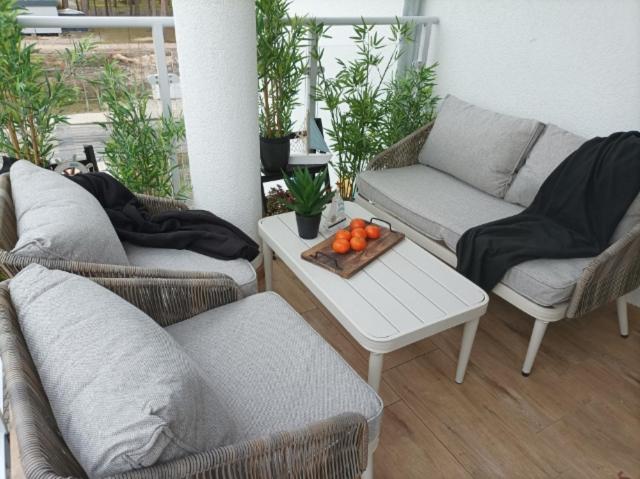 d'une terrasse avec deux canapés et une table avec des oranges. dans l'établissement Apartament Słoneczny, à Dziwnówek