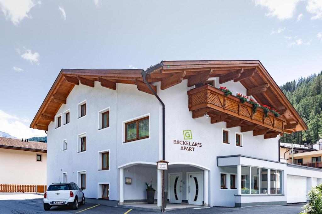 a large white building with a wooden roof at Bäckelar‘s Apart in Sölden