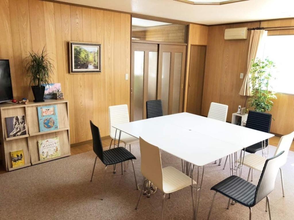 une salle de conférence avec une table et des chaises blanches dans l'établissement Guest House Nusa - Vacation STAY 12651, à Kushiro