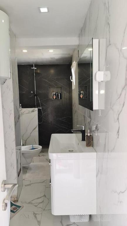 a white bathroom with a sink and a toilet at Sea side apartment in Kotor