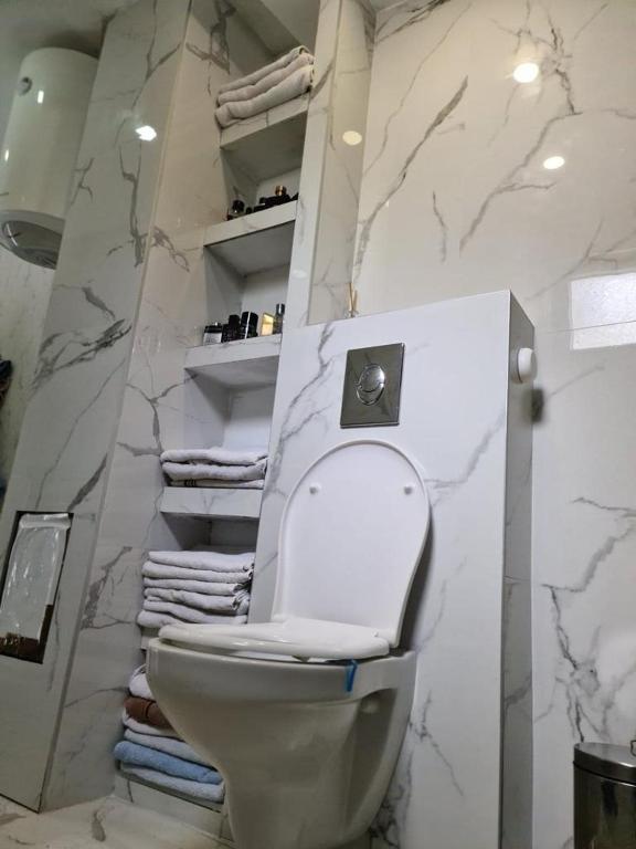 a bathroom with a toilet and a pile of towels at Sea side apartment in Kotor