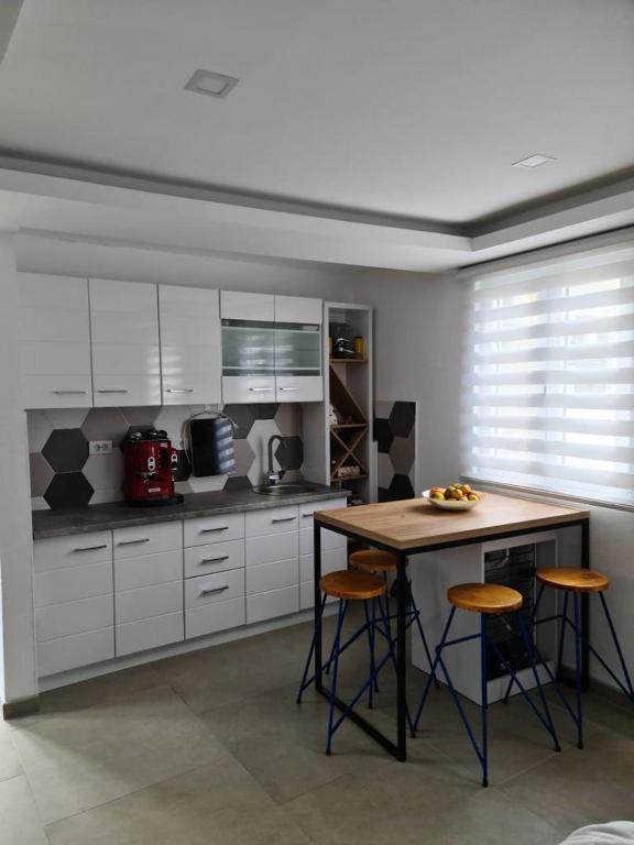 a kitchen with white cabinets and a table and stools at Sea side apartment in Kotor