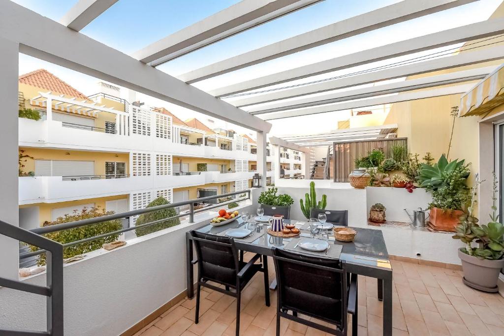 a patio with a table and chairs on a balcony at Penthouse Dali - Cabanas Beach Club in Cabanas de Tavira