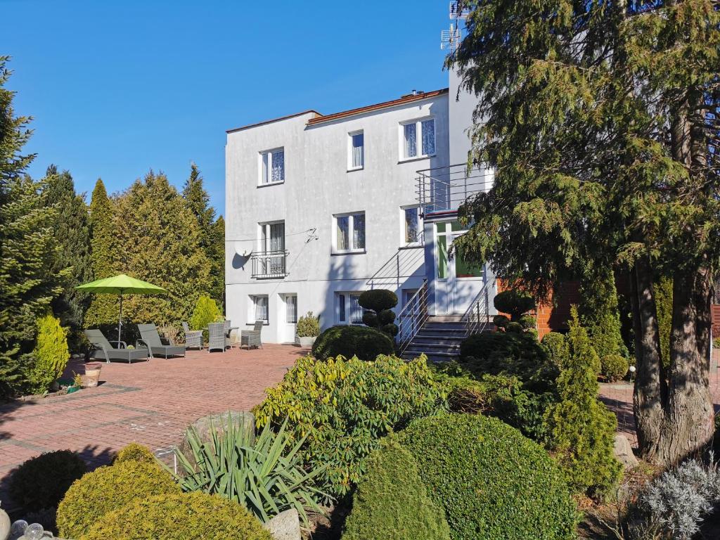 duży biały budynek z patio przed nim w obiekcie Pokoje gościnne Simon w mieście Mielno