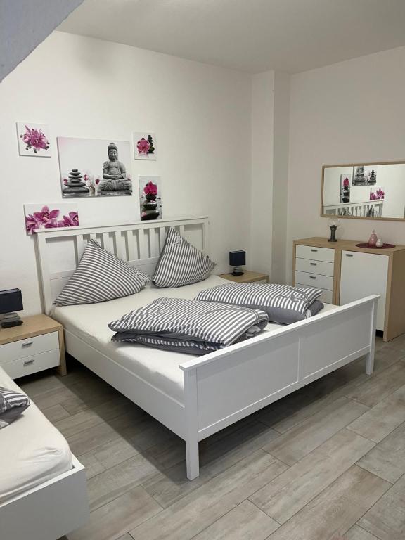 a bedroom with a white bed with pillows on it at Sweet Home Appartements in Bottrop