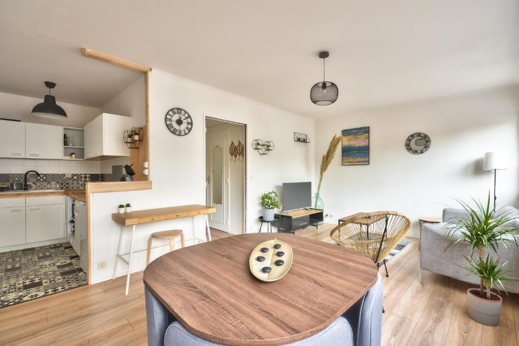 a kitchen and living room with a table and chairs at Appartement Rouen centre: Hôtel de ville, CHU, conservatoire in Rouen