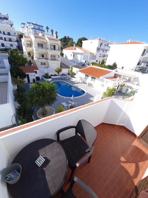 een patio met een tafel en een stoel op een balkon bij Apartamentos Julieta in Albufeira