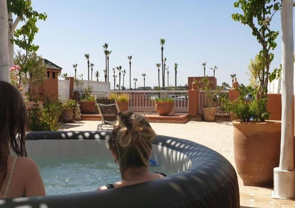 una mujer sentada en una piscina en una piscina en "LE 21", EXCLUSIVE DUPLEX 400m from Jemaa el Fna - JACUZZI - HAMMAM - NETFLIX - HIGH-SPEED WIFI, en Marrakech