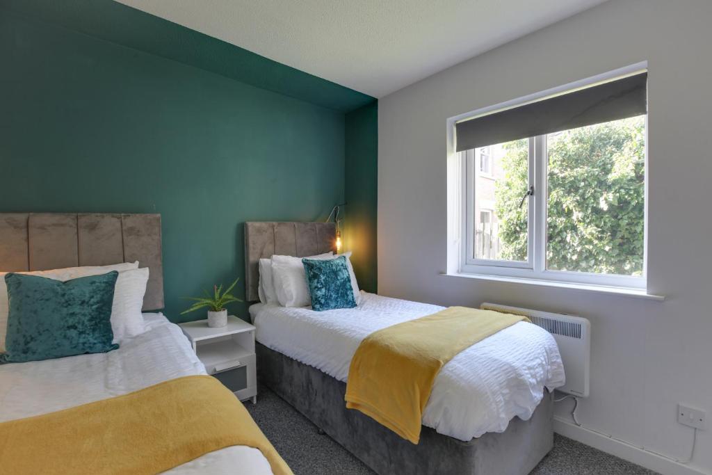 1 Schlafzimmer mit 2 Betten und einem Fenster in der Unterkunft George Suite - Free Parking and WiFi in Chelmsford
